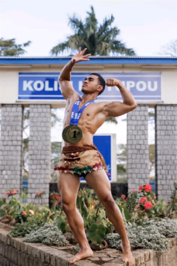 Bodybuilding competition winner with gold medal and ta’ovala